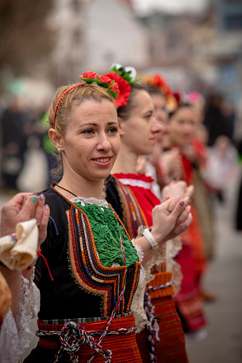 Kyustendil, Bulgaria - February 10, 2024: First edition of a masquerade festival in Kyustendil Bulgaria. Women dressed in Bulgarian folk costume dance and perform a ritual of fertility and health.