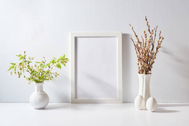 istock Mockup with a white frame and spring flowers in a vase, easter eggs on a light background. Empty poster frame mockup for presentation design, text, lettering 2008151597