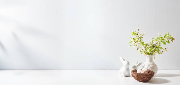 istock Spring flowers in a vase and easter bunny on a white table. Easter background with copy space 2008151605