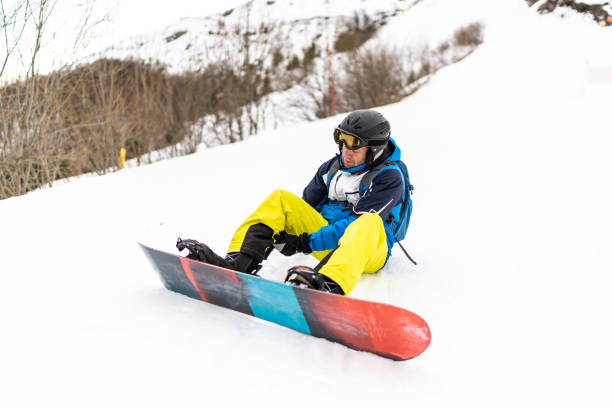 istock Shot of a young man putting a snowboard while on a mountain trip 2008159748