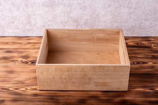 Wooden box with cover on a wooden table.
