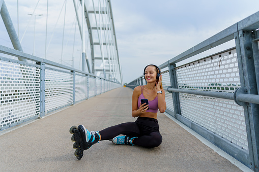 The bridge becomes a stage for a woman on rollerblades, her headphones blasting the perfect soundtrack to accompany the thrill of speed and the joy of movement