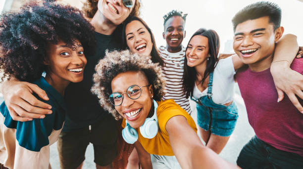 istock Multicultural friends taking selfie pic with smart mobile phone outdoors - Group of different young people smiling at camera together - Youth community concept with guys and girls hanging outside 2008192265