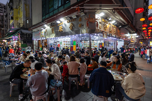Hong Kong - February 13, 2024 : People at the Temple Spicy Crabs restaurant in Temple Street, Kowloon, Hong Kong.
