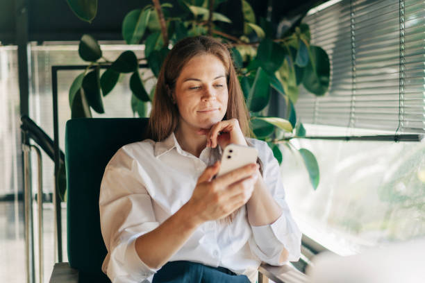 istock A woman uses a mobile phone to communicate while sitting in a coffee house. 2008216853
