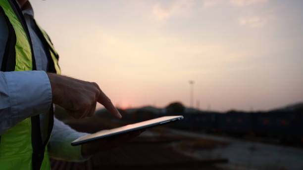 istock Smart engineer hold laptop work outside at sunset in a transportation yard 2008266181