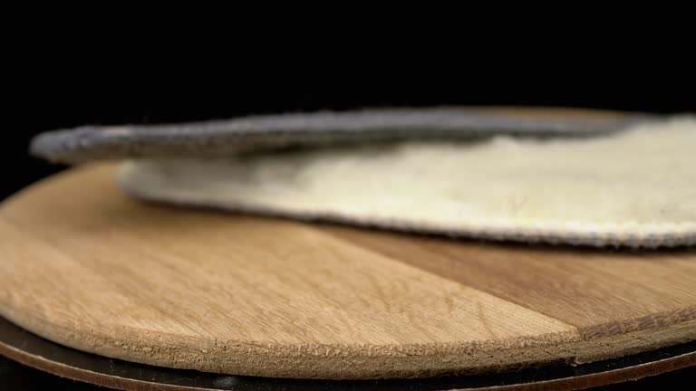 Close up, Warm Woolen Shoe Insoles Rotate on a Wooden Board, Black Background