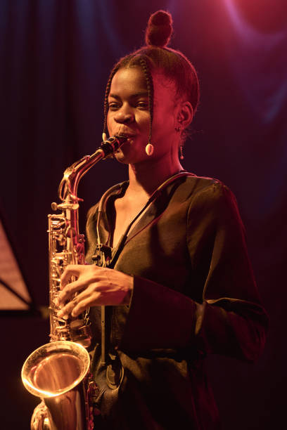 istock Black Woman Playing Saxophone on Stage with Jazz Band 2008322795