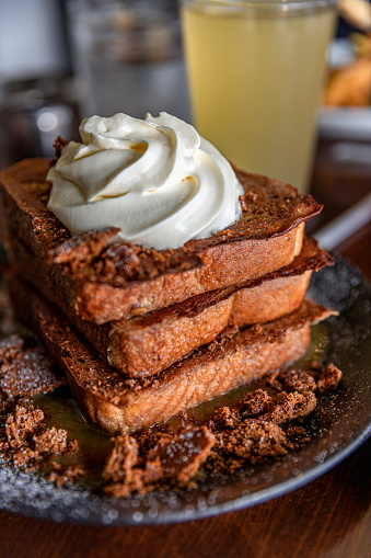 A refreshing glass of lemonade is placed alongside a delectable stack of French toast