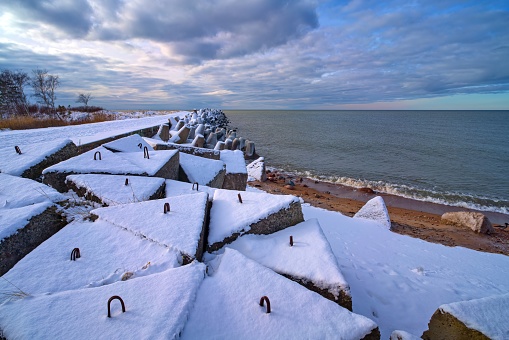 The breakwater is covered with snow. Baltic Sea. Winter landscape.