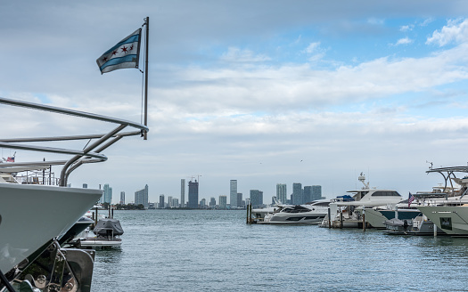 Luxury boats in a Miami Beach marina, in the background you can see the growing profile of the city of Miami.