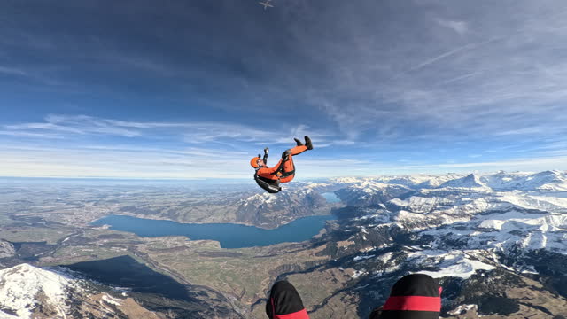 Wingsuit flier soars above Swiss mountain landscape