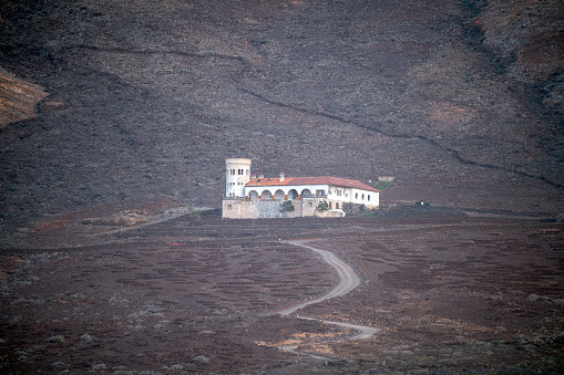 This mesmerizing photograph transports viewers to the mystical realm of Casa de los Winter in Cofete, Fuerteventura, Canary Islands. Captured from a distance with a zoom lens, the villa emerges like a hidden gem amidst the enigmatic landscape.