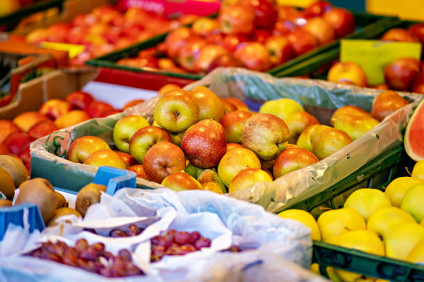 Close-up shot of unrecognizable African woman choosing fresh organic peaches at farmer's market