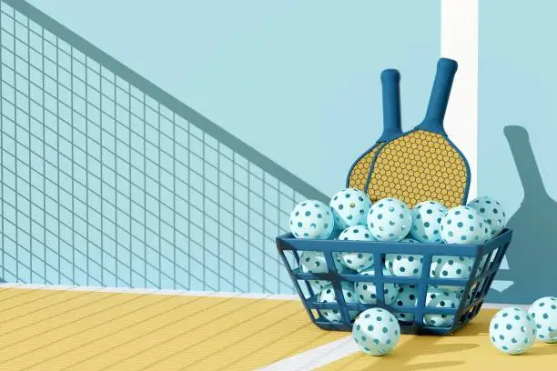 Photo of Pickleball sport equipments. Two rackets and basket of balls under the shadow of the grid on court. 3d illustration, render. Copy space