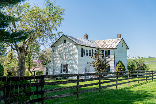 Split-Rail Fence and Back Yard of a Colonial-Style Brick Ranch Home on a Farm in Maryland, USA in the Springtimer