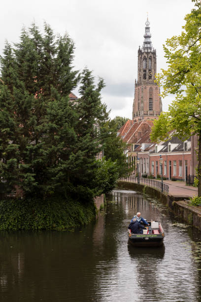 Amersfoort, Netherlands, August 1, 2023; People sail in a small boat through a canal in Amersfoort.
