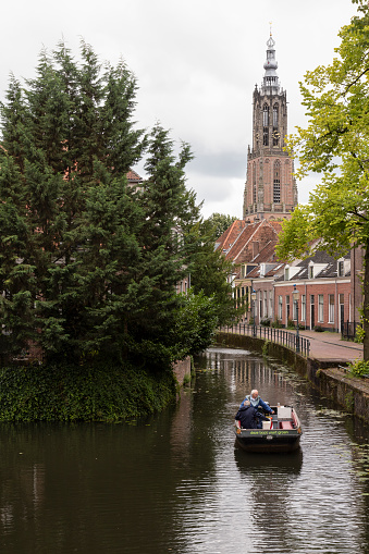 Amersfoort, Netherlands, August 1, 2023; People sail in a small boat through a canal in Amersfoort.