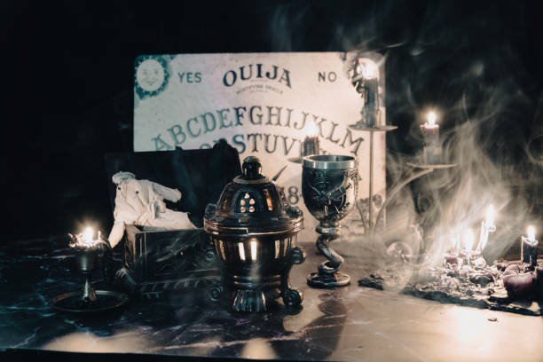 istock A worn rag doll lies in a haunting occult setting with a Ouija board backdrop, invoking a sense of mystery. 2008502689