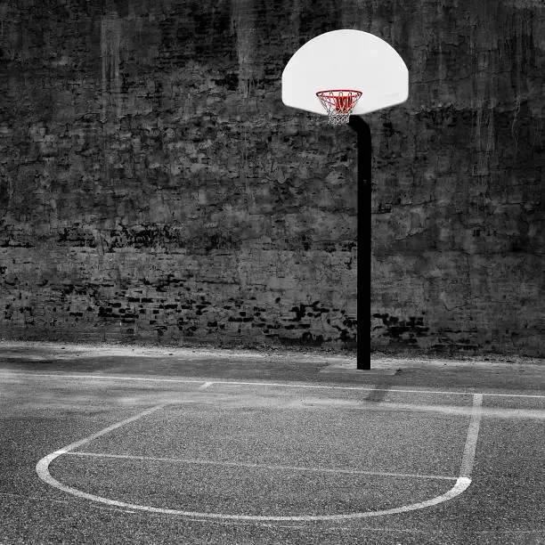 Detail of urban basketball hoop inner city innercity wall and asphalt in outdoor park