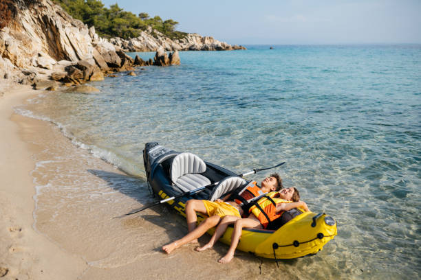 teenagers having fun with inflatable raft on their summer vacation - child inflatable raft lake family - fotografias e filmes do acervo