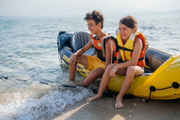 teenagers having fun with inflatable raft on their summer vacation - child inflatable raft lake family 뉴스 사진 이미지