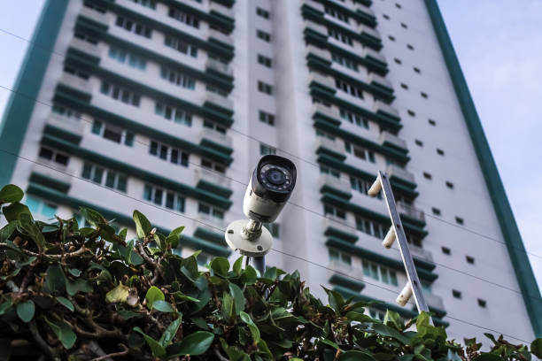 istock Residential condominium security system - Security camera and electric fence with building in the background 2008585976
