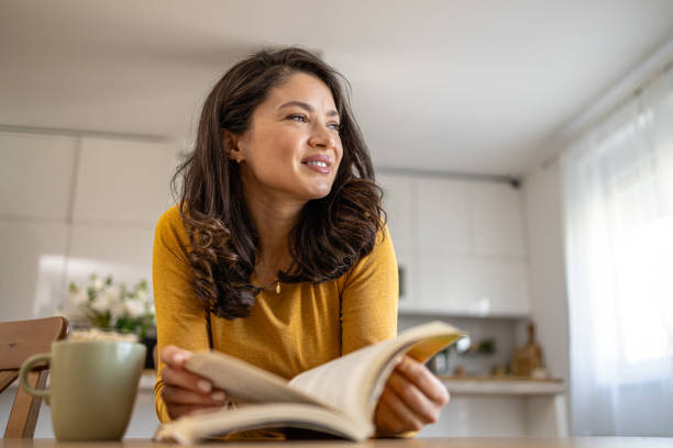 istock A young woman reading a book and drinking coffee 2008666477