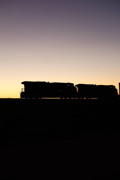 istock Train pushing its cargo across the desert at sunrise 2008668033