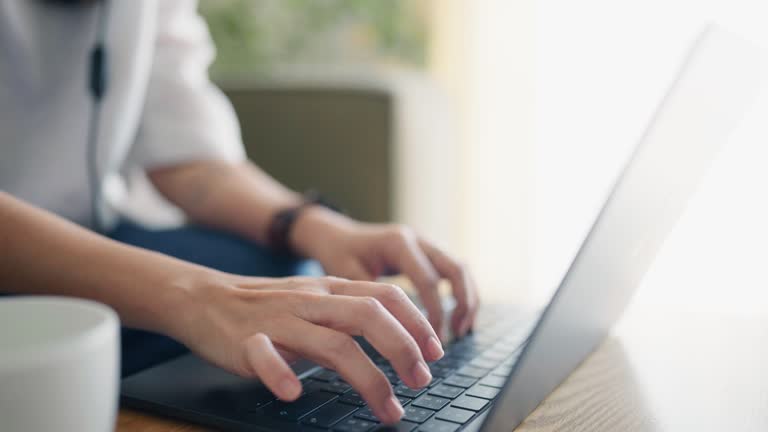 Close-up of a female employee's hand typing something on a tablet.