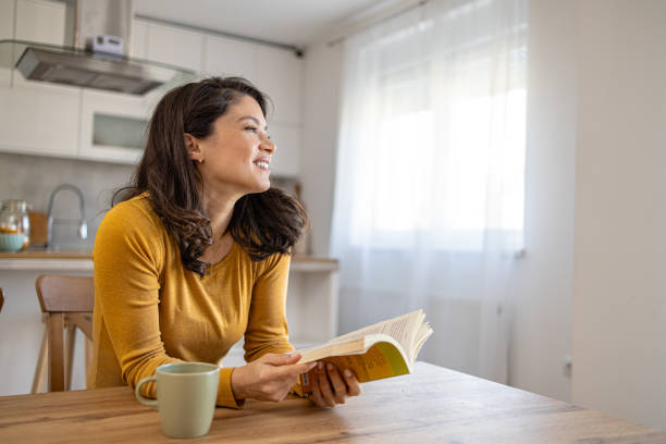 istock A young woman reading a book and drinking coffee 2008676991