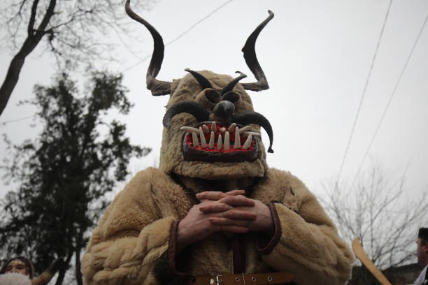 Pernik, Bulgaria - January 29, 2011: Unidentified man with traditional Kukeri costume are seen at the Festival of the Masquerade Games Surva in Pernik, Bulgaria. Surva takes place the third weekend of January and it's the biggest event of this type in Bulgaria. Photo taken on: January 29th, 2011