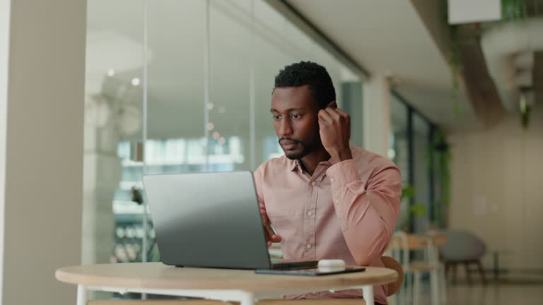 Laptop, business and black man in office with earbuds for streaming music, webinar and online videos. Corporate, professional and person on computer for internet listening to podcast, radio and audio