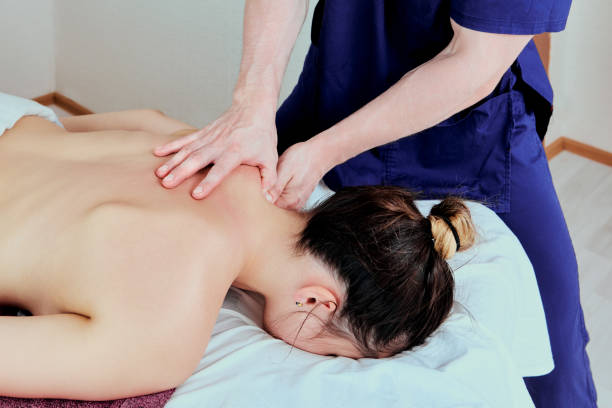 istock Woman lying face down on massage table, young Caucasian woman undergoing physiotherapy treatments. 2008695481