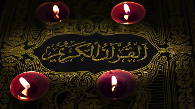 Religion The Book of Islam Quran in Candle Light