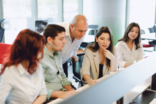 istock Dynamic Business Collaboration: Multiracial Business Team Engaged in a Productive Staff Meeting. Diverse Group  Planning Strategically, Brainstorming, Collaborating, and Working a Modern Office Setting 2008821918