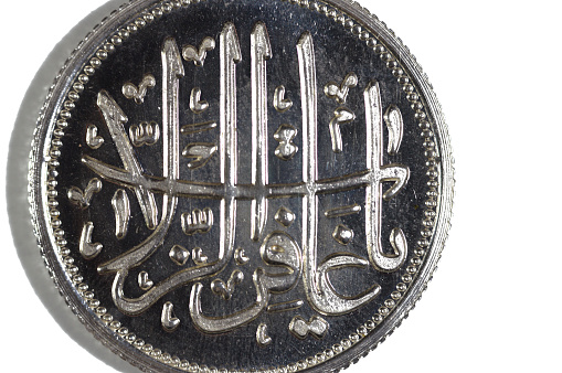 Translation of the Arabic text (O forgiver of transgressions), Islamic pure silver ounce coin, The price of silver is driven by speculation, supply and demand and it's usually bought as an investment, selective focus