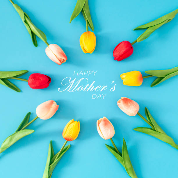 istock Creative spring composition made with colorful tulip flowers with Happy Mother's day text on blue background. Minimal Mothers day concept. Trendy spring flowers idea. Nature flat lay. 2008873860