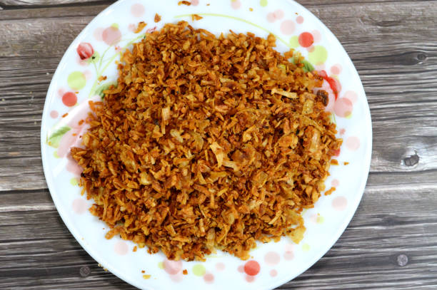 Fried onions, that is used for topping of Koshary Egyptian cuisine, lentils, rice, chickpeas, with a special tomato sauce and savory crispy onions on top, sliced onions, salt, cornstarch then fried Fried onions, that is used for topping of Koshary Egyptian cuisine, lentils, rice, chickpeas, with a special tomato sauce and savory crispy onions on top, sliced onions, salt, cornstarch then fried, selective focus koshary stock pictures, royalty-free photos & images