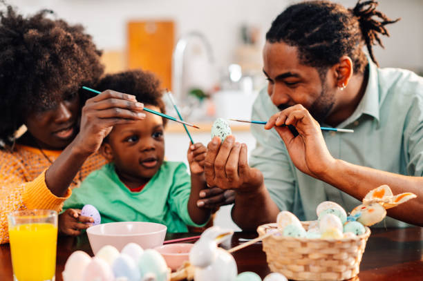 istock Happy black family is painting easter eggs on easter saturday. 2008915513