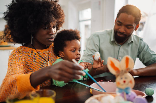 istock Multicultural family sits at home and coloring easter eggs on easter. 2008915534