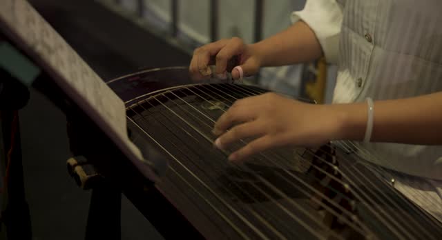 woman playing Guzheng instrument
