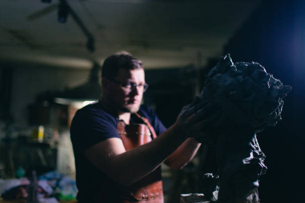 Man sculptor creates sculpt bust clay human woman sculpture. Statue craft creation workshop.