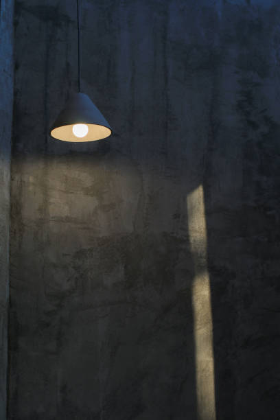 istock Ceiling Light Bulb in the Empty Concrete Room Interior. Grunge industrial background. Dark room with walls of concrete 2009006133