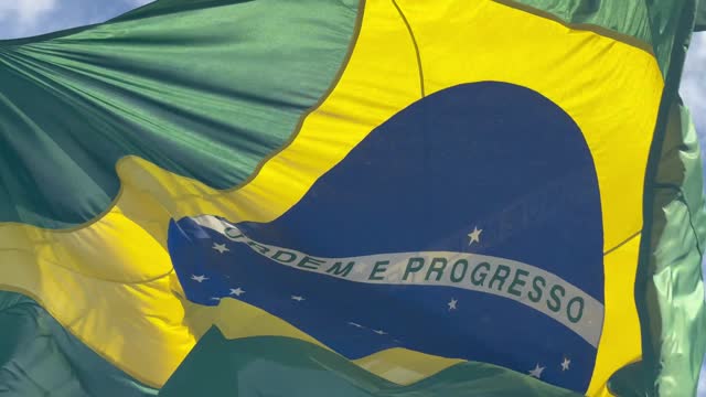 Brazilian waving flag in a blue sky