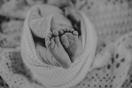 Black and white photo with tiny newborn toes