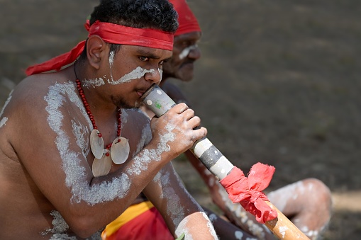 Laura,Qld- July 08 2023:Indigenous Australians play didgeridoo on ceremonial dance in Laura Quinkan Dance Festival Cape York Australia. Ceremonies combine dance, song, rituals, body decorations and costumes