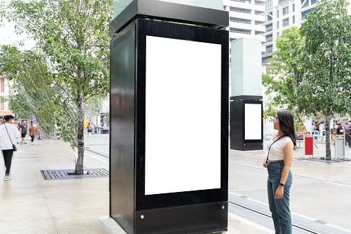 Blank white billboard. Street mockup. Banner board advertising posters. Digital advertising lightbox located in the middle of the walkway. vertical format label.