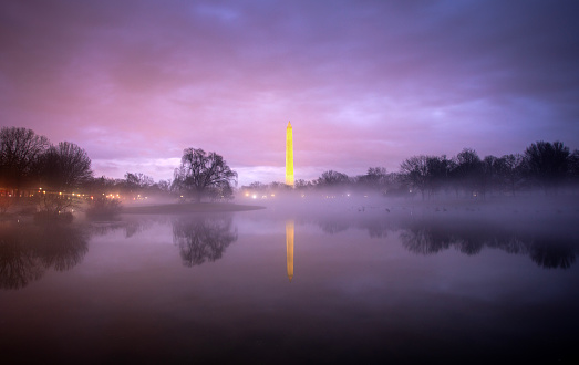 The Washington Monument rises out of the mist against a pink sky, Washington DC