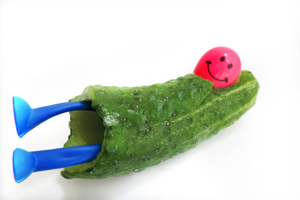 Funny cucumber with eyes on beige background. Halloween holiday idea. Creative still life, copy space.